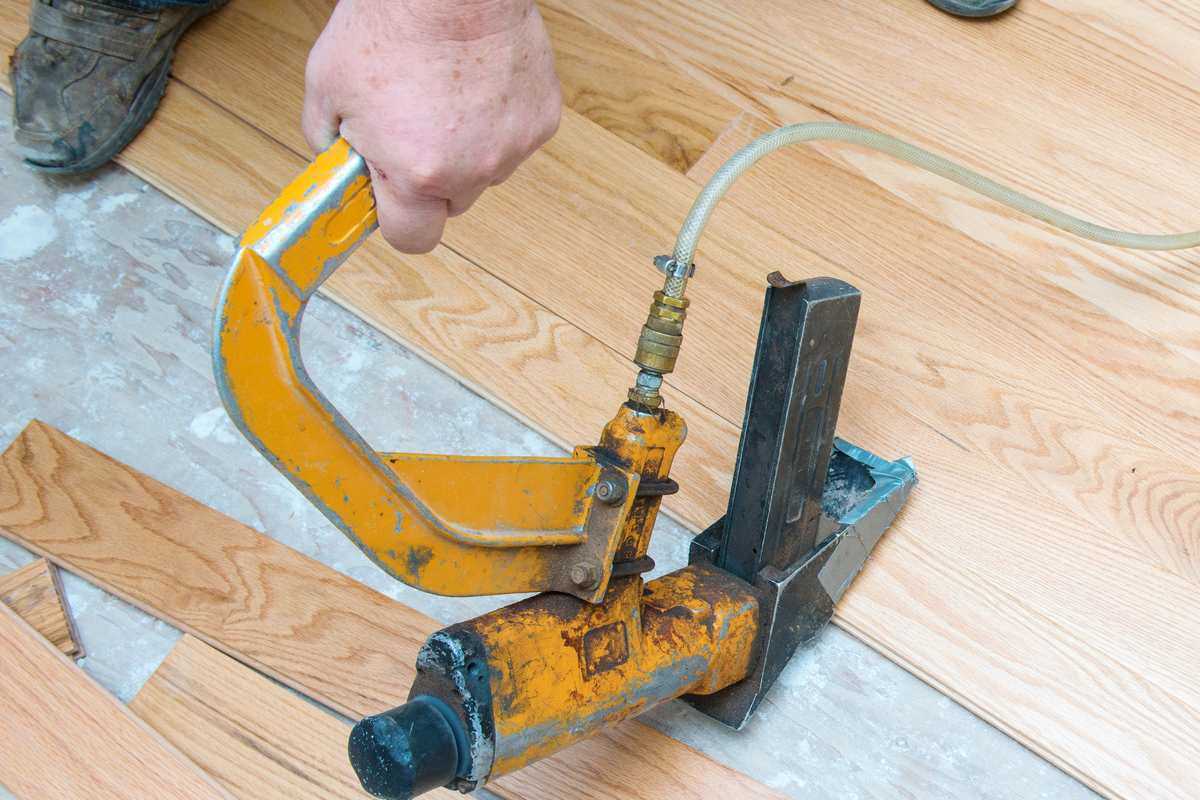 Professional Using Tools To Install Hardwood Flooring