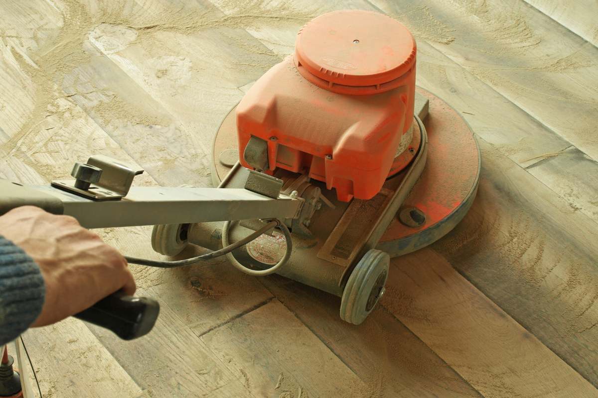 Man Sanding A Floor With Sanding Machine