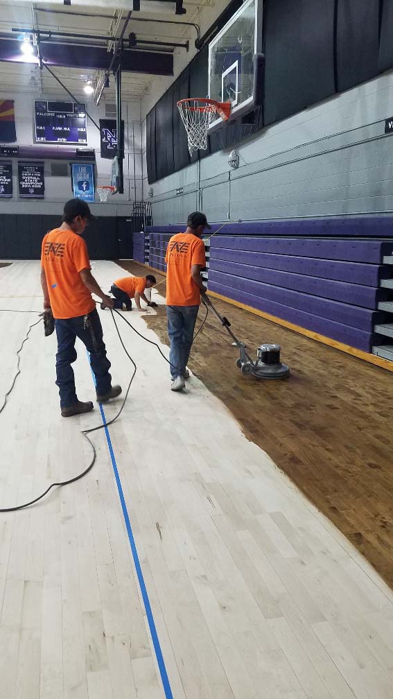 Applying stain to gym floor