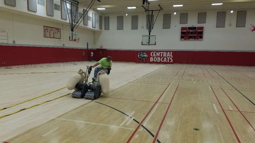 Sanding the gymnasium flooring Sanding the gymnasium flooring